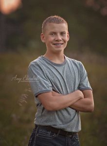 teen boy with arms crossed smiling