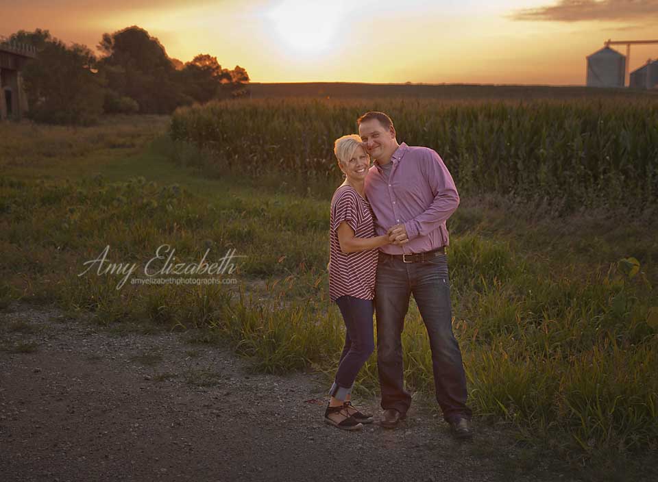 husband and wife by cornfield at sunset manning iowa