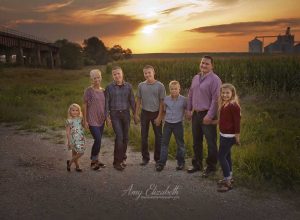 family by cornfield at sunset