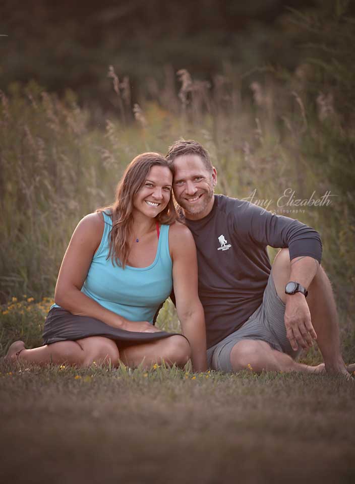 couple sitting in front of tall grasses