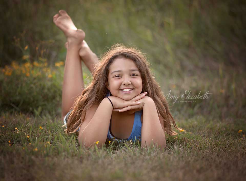 preteen laying on grass