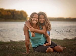 mother and daughter all smile by lake