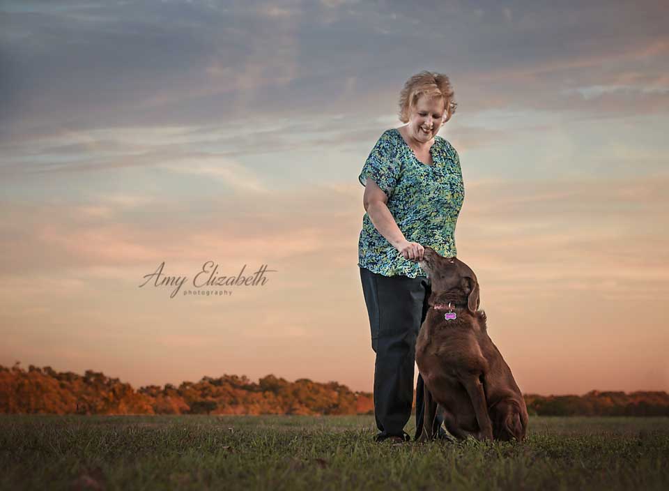 beautiful sky behind owner and chocolate lab dog