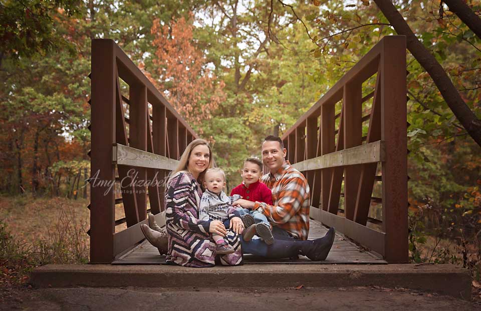 family pictures with two boys sitting on bridge