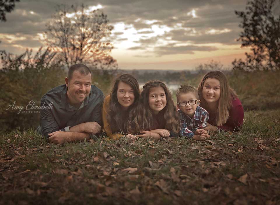 family of five with sunset sky