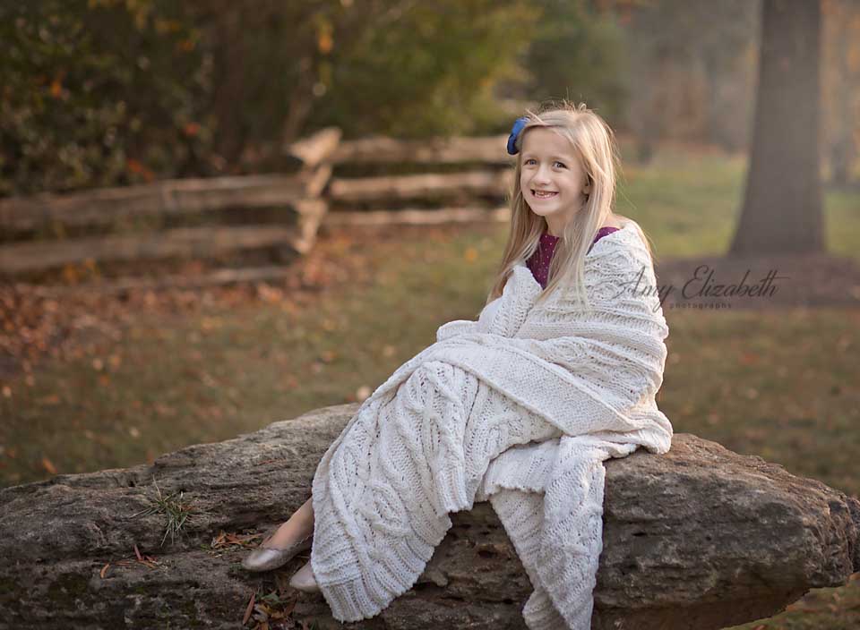 little girl wrapped in white blanket for fall family pictures