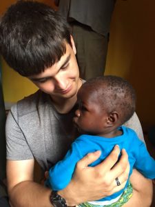 son holding baby in Uganda
