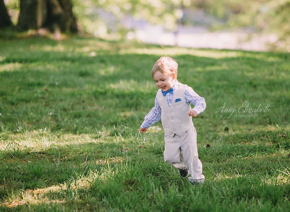 little boy running through grass