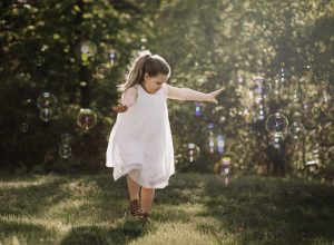 little girl dancing in bubbles