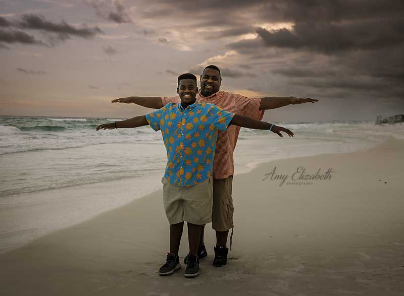 father and son posing fun on beach